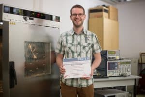 Florian Strakosch im „Smart Diagnostics“-Labor der HTWK Leipzig. In der Klimakammer (links) wurde das Getriebe simuliert, die Messtechnik (rechts im Bild) erzeugte und wertete die Funksignale aus. Foto: Robert Weinhold/HTWK Leipzig