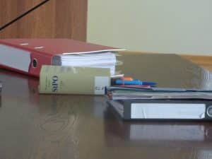 Gesetzesbuch und Ordner auf Tisch.