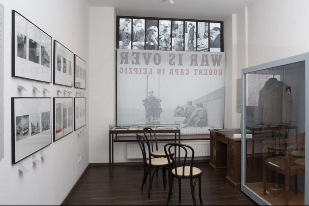 Medienstation mit dem Originalschreibtisch aus der Wohnung, in der Robert Capa die Fotoserie „The Last Man to Die“ aufnahm. Foto: Thomas Raatz, Stadtgeschichtliches Museum Leipzig