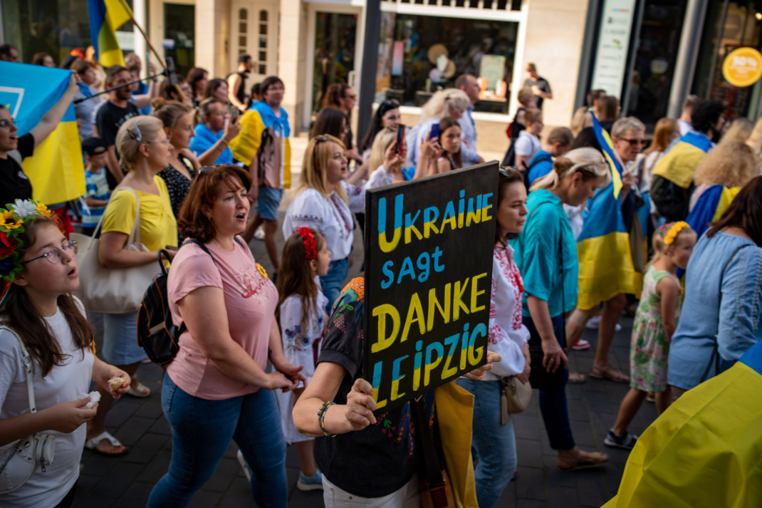 Ukraine-Demo, Menschen haben sich mit Flaggen und Schildern versammelt.