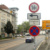 Befahrene Fahrbahn, Wohnhäuser, Verkehrsschilder.