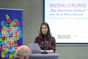 Junge Frau am Rednerpult. vortragend.