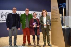 Vier Personen, nebeneinander stehend.