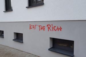 Graffiti-Aufschrift an heller Hauswand.