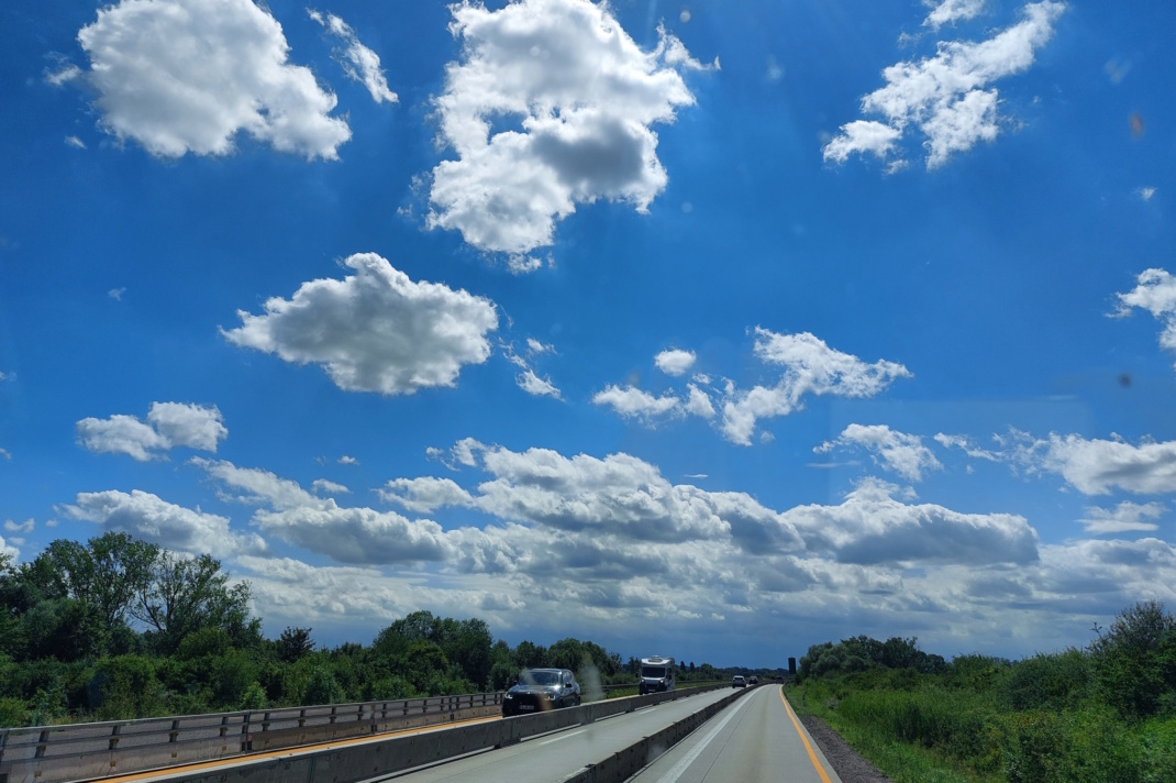 Autobahn, blauer Himmel und Wolken.