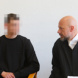 Angeklagter (verpixelt) spricht mit seinem Anwalt.