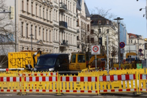 Baustelle im Wohngebiet mit Absperrung,und Fahrzeugen.