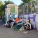 Alttextilien häufen sich neben dem vollen Kleidercontainer.