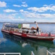 Boot nahe des Stegs auf einem See, Himmel und Wolken.